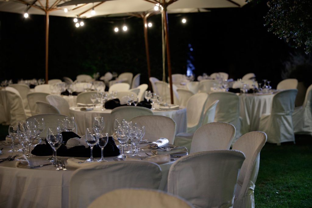 Tavoli allestiti in giardino per una cena serale